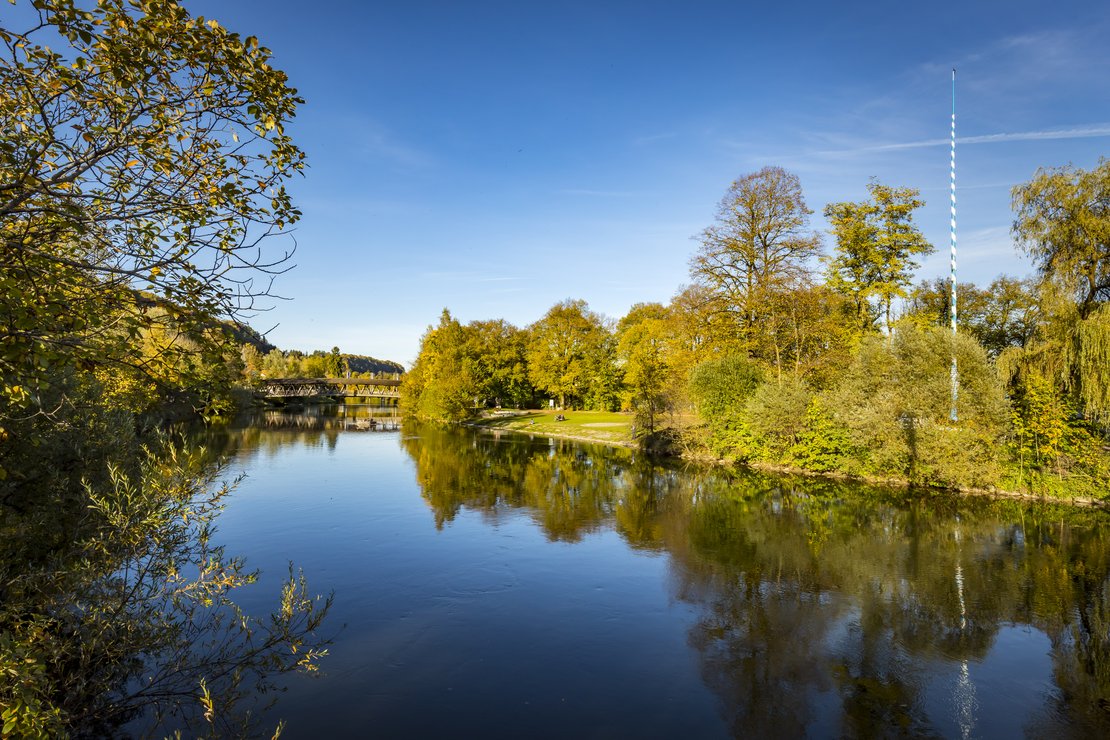 Ein Fluß fließt durch eine grüne Lanschaft.